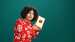 Curious, gift box and black woman in studio for christmas tradition, festive or surprise secret santa. Giveaway, mockup space and African person with xmas present for holiday by green background.