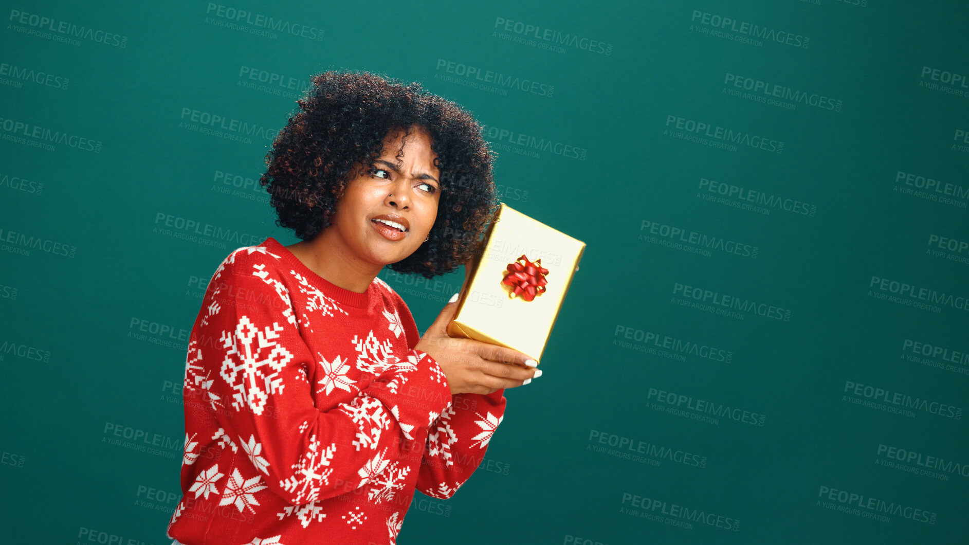 Buy stock photo Curious, gift box and black woman in studio for christmas tradition, festive or surprise secret santa. Giveaway, mockup space and African person with xmas present for holiday by green background.
