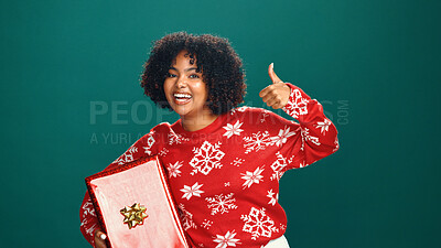 Buy stock photo Christmas, present and thumbs up with portrait of woman in studio for celebration, motivation or success. Box, gift and smile of happy person on green background for festive holiday or tradition