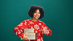 Christmas, gift and portrait of woman in studio for holiday season, celebration or pointing. Festive event, xmas vacation and present with person on green background for space and December cheer