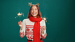 Christmas, portrait and woman laughing with sparklers in studio for holiday celebration. Person, happy and fireworks for xmas, festive season and excited on green background with mockup space
