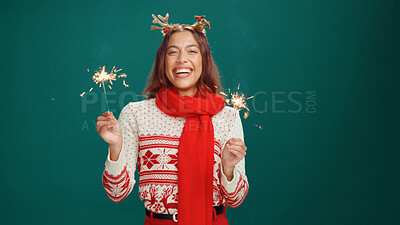 Buy stock photo Christmas, portrait and woman laughing with sparklers in studio for holiday celebration. Female person, happy and sparks for xmas, festive season and excited on green background with mockup space