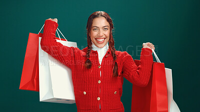 Buy stock photo Christmas, shopping bags and portrait of woman in studio for holiday season, celebration or smile. Festive event, xmas vacation and retail deal with person on green background for sale and December