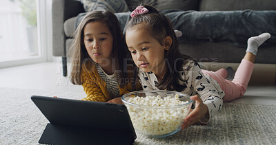 Buy stock photo Girl, siblings or watching with tablet in home for online entertainment or subscription. People, child or sister streaming with technology or popcorn for movie, snack or bonding together on floor