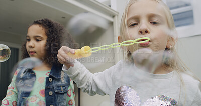Buy stock photo Friends, children and blowing bubbles by home for game, bonding and outdoor. Playing, kids and girl with soap toys, wand and entertainment with freedom by house with portrait together on weekend