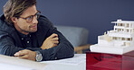 Thinking, man and architect with model in office for real estate, illustration and building design. Male person, 3d prototype and check project planning, property development and expansion structure