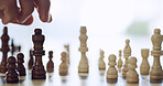 Closeup, person and hand for playing chess with move decision, piece strategy and game competition. Thinking, contest and king choice for battle, sports tournament and challenge for winning checkmate