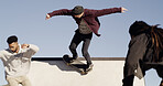 Men, skateboard and friends on ramp at park with trick, outdoor and culture with streetwear in city. People, skater group and training with balance, hobby and low angle with sky for extreme sports