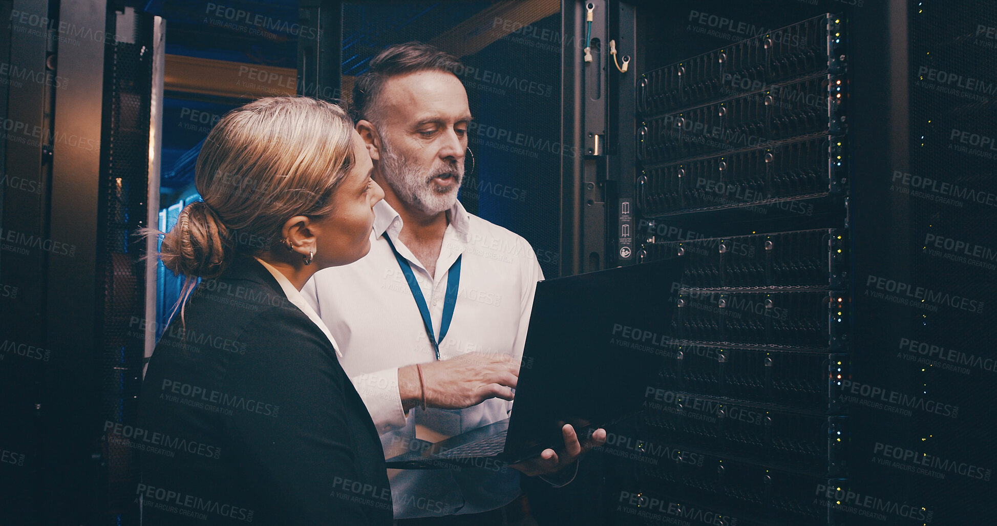 Buy stock photo Server room, talking and people on laptop for technical support, network maintenance and database. IT technicians, team and man with woman on computer for diagnostics, system update and cybersecurity