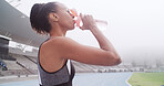 Drinking water, sports and woman in stadium for exercise, training and workout on running track. Fitness, athlete and person with liquid, bottle and thirsty for wellness, health and hydration outdoor