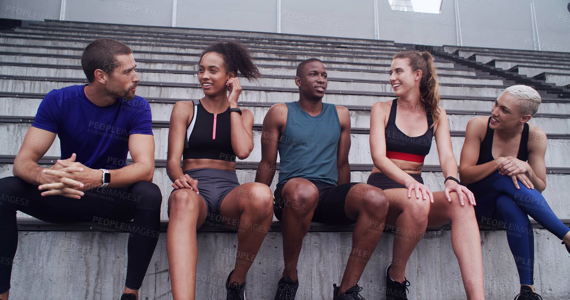 Buy stock photo Conversation, break and fitness with friends on stadium bleachers for bonding or sports training. Exercise, recovery and rest with group of athlete people speaking in venue for workout discussion