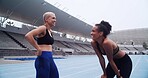 Conversation, fitness and girl friends on race track for workout, practice or training for marathon. Talking, laughing and female athletes with cardio exercise, sports or running for health at arena.