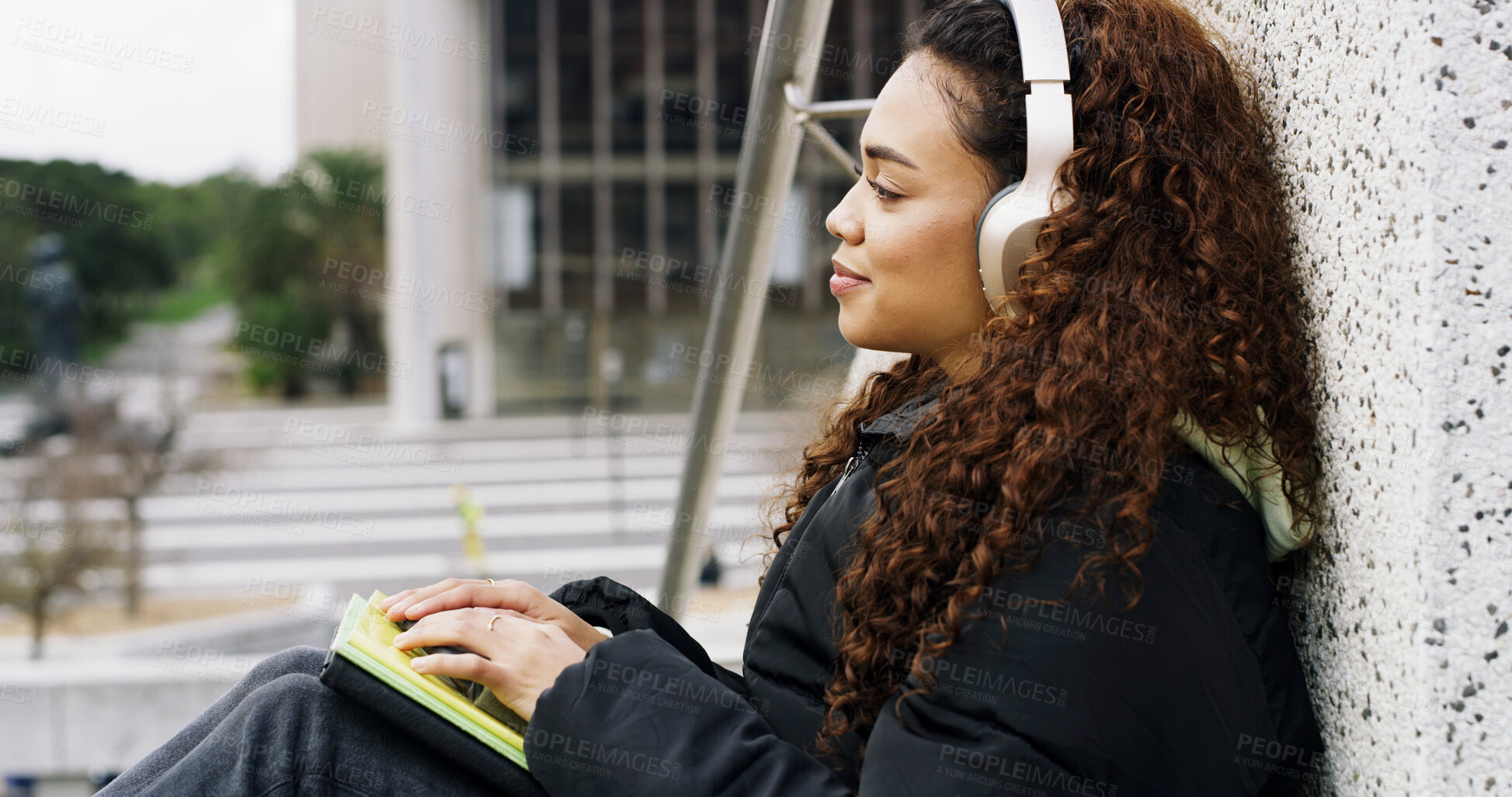 Buy stock photo Headphones, student and woman with notebook in city for music, podcast and audio on college break. University campus, thinking and person listening to radio, track and playlist in town on weekend