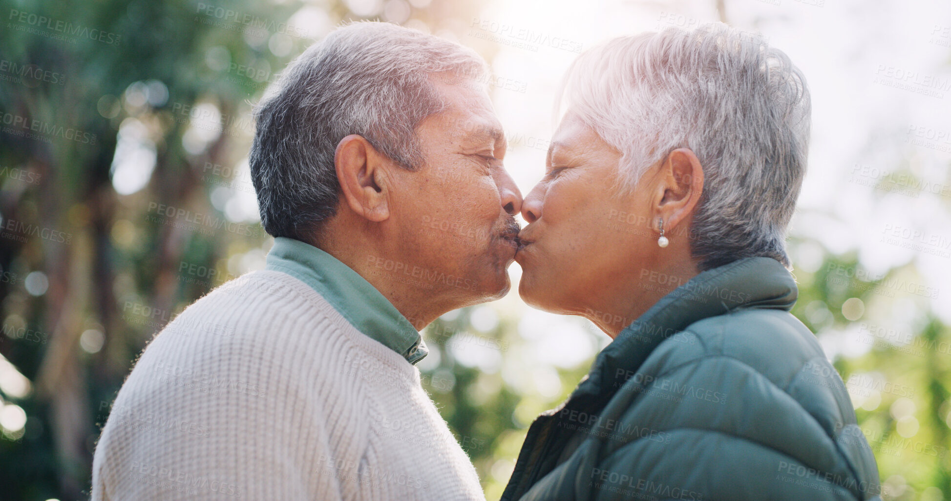 Buy stock photo Kiss, love and retirement with old couple in park together for bonding, break or wellness. Affection, relationship and weekend with senior people outdoor in nature for commitment or connection