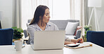 Calculator, laptop and writing with woman in living room of home for notes, planning or remote work. Computer, finance and money with freelance employee at desk in apartment for accounting or budget