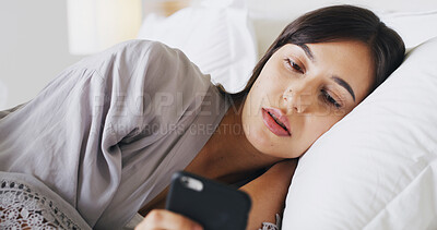 Buy stock photo Serious, phone and woman relax in bedroom for text, message or reading post on social media. Morning, bed and girl in home for communication, check news and online chat with internet notification