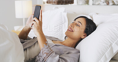 Buy stock photo Smile, phone and woman relax in bedroom for text, message or reading post on social media. Morning, bed and girl in home for communication, check news and online chat with internet notification