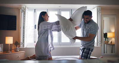 Buy stock photo Couple, happy and pillow fight on bed with love, playful and relationship development in home. Man, woman and cushion war in bedroom for silly game, bonding and excited with energy in apartment