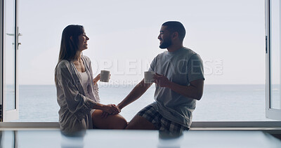 Buy stock photo Ocean, window and couple with coffee, smile and bonding together with romance, talking and relationship. Home, seaside and man with woman, story and espresso with break, conversation or holding hands
