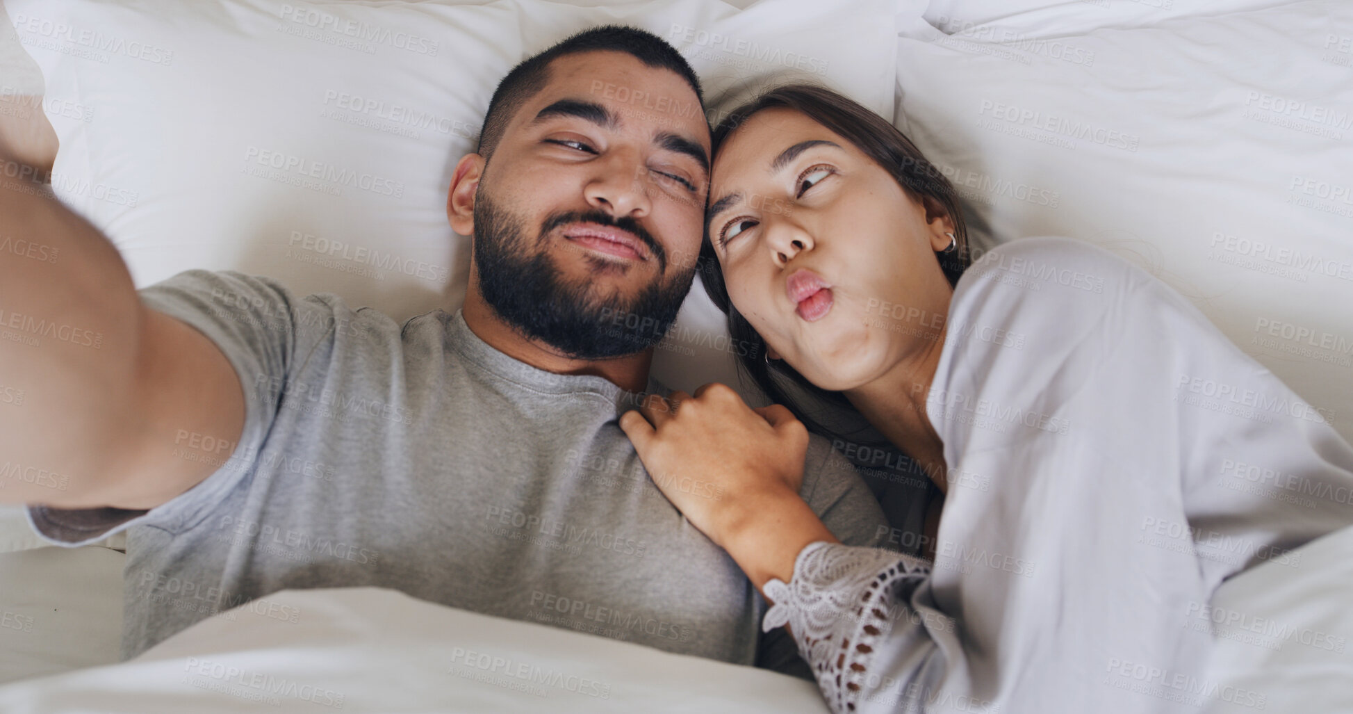Buy stock photo Morning, couple and selfie with goofy face, smile and love for romance in bedroom. Above man, woman and funny with honeymoon memory, photography and hotel room for vacation and social media post