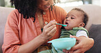 Food, mother and feeding baby in home for nutrition, morning routine and healthy development. Love, motherhood and happy woman with infant formula on sofa for breakfast, hungry and eating for growth
