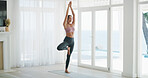Woman, house and tree pose with prayer hands for exercise, yoga and balance by window for health. Female person, wellness and posture with namaste, mindfulness or fitness with zen in apartment