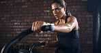 Athlete, woman and exercise with bicycle at gym for fitness, intense training and endurance. Female person, sweating and stationary bike for cardio workout, cycling performance and sports challenge