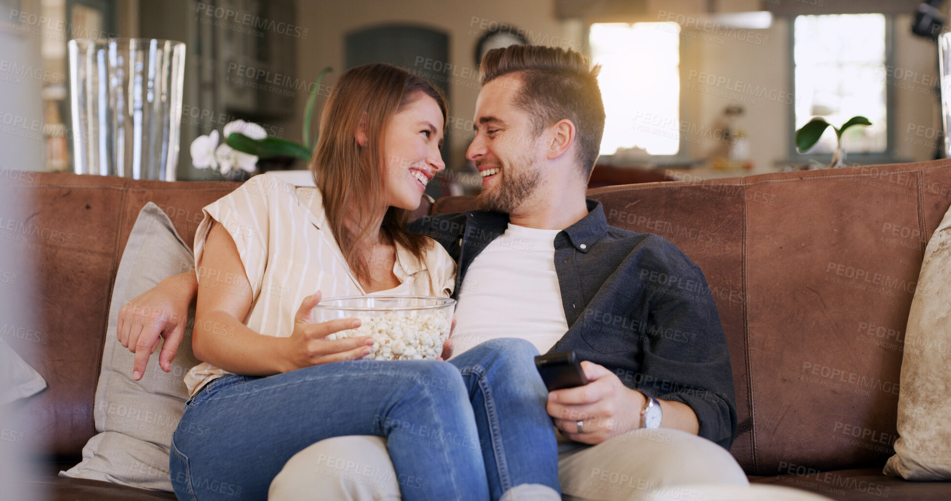 Buy stock photo Popcorn, happy and couple on sofa in home with watching movie, series or show together. Smile, love and man with woman streaming film with snack in living room for date on weekend break in apartment.