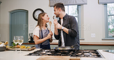 Buy stock photo Love, couple and cooking with singing in kitchen for dinner date, meal prep and anniversary karaoke. Happy, people and wooden spoon for relationship song, music performance and lunch recipe in home