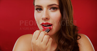 Buy stock photo Portrait, woman and lipstick for makeover in studio with makeup, facial beauty and foundation glow. Female person, cosmetics and apply for bold glamour, lip color and change results on red background