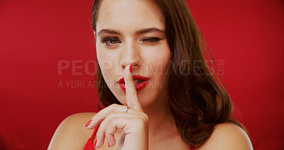 Buy stock photo Woman, portrait and wink with hush, studio and silence for mystery announcement. Model, gossip and beauty secret with rumor, whisper and gesture for news or noise with privacy on red background
