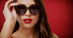 Beauty, sunglasses and portrait of woman in studio for fashion, trendy style and cosmetics. Space, aesthetic and face of confident person with accessories, makeup and red lipstick on color background