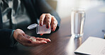 Water, pills and hands of person in home for medical treatment, prescription and tablets for recovery. House, health and patient with medication container for vitamins, supplements and drugs on table