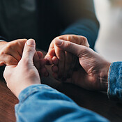 Holding hands, table and couple in home for support, empathy and ...