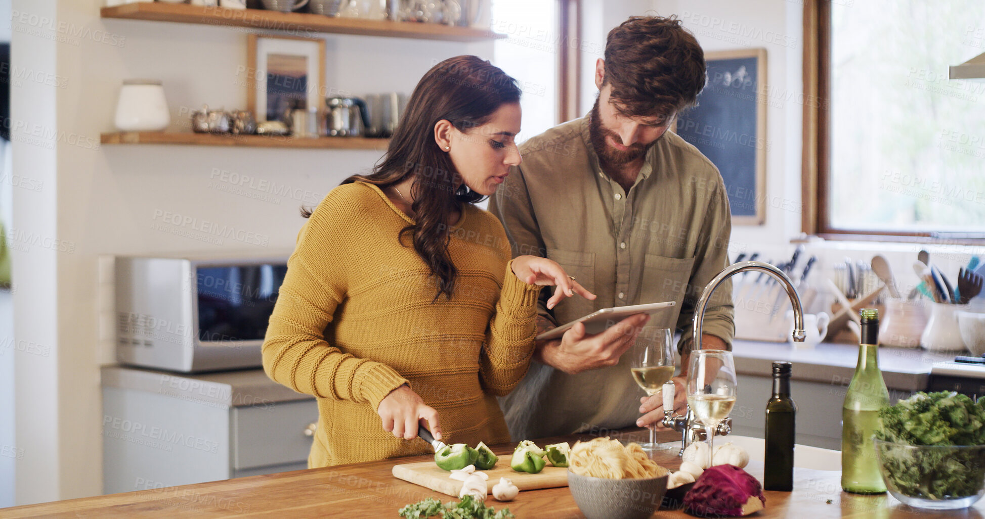 Buy stock photo Tablet, cooking and couple cut vegetables with help, online tutorial or meal prep. Tech, man and woman with chopping board for organic food guide, pepper or healthy recipe with wine in home kitchen