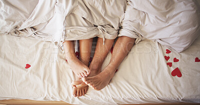 Buy stock photo Heart, legs and romance with couple in bed together from above for bonding, dating or love. Feet, relationship and relax with people in bedroom of home for anniversary, honeymoon or valentines day