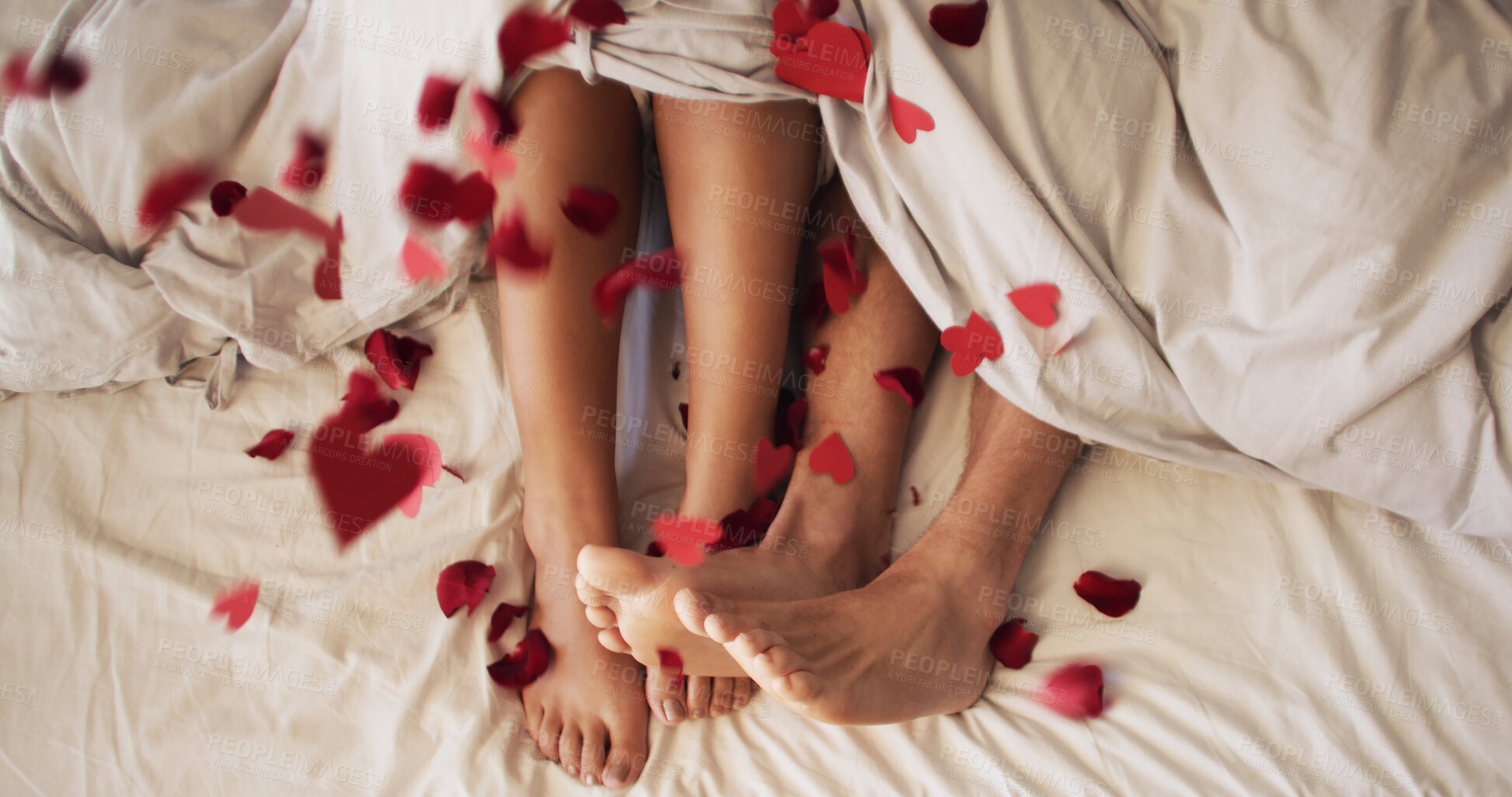 Buy stock photo Confetti, feet and heart with couple in bed together from above for bonding, dating or love. Legs, petals and relationship with people in bedroom of home for anniversary, honeymoon or valentines day
