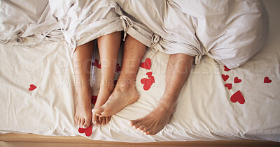 Buy stock photo Feet, heart and romance with couple in bed together from above for bonding, dating or love. Legs, relationship and relax with people in bedroom of home for anniversary, honeymoon or valentines day