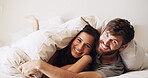 Couple, portrait and cuddle in bed with happiness, moment and connection for bonding in home. Woman, man and under blanket for romance, smile and rest with commitment, trust and comfort in bedroom