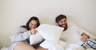 Buy stock photo Bedroom, couple laugh and pillow fight for love, playful partner and excited together in morning. Home, man and woman with cushion for game in bed, funny and bonding with happiness in apartment