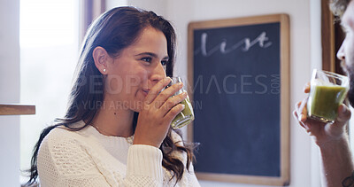 Buy stock photo Woman, smoothie and smile with glass in kitchen, care and bonding for nutrition at apartment. Happy couple, man and love with green drink, benefits or diet with organic detox for gut health at house