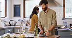 Cooking, tablet and wine with couple in kitchen of home together for meal preparation. Drink, ingredients and online recipe with man and woman in apartment for diet, healthy eating or nutrition