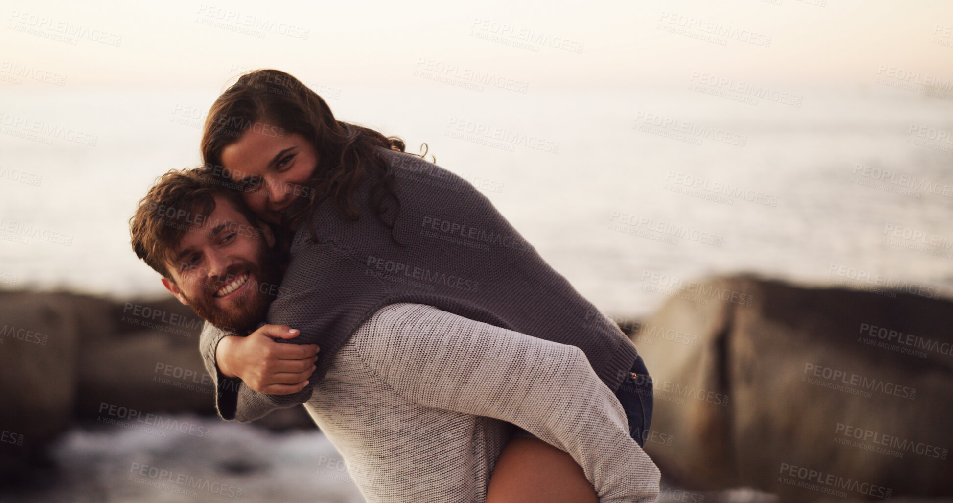 Buy stock photo Ocean, love and happy couple with piggyback on holiday, vacation and date together. Smile, man and woman with hug at beach for romance, connection and travel with portrait of partner outdoor at space