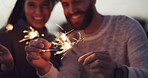 Hands, sparkler and couple at night, outdoor and celebration with love, anniversary or birthday. People, fireworks and excited with bonding, party and holiday at twilight for new years eve in Spain