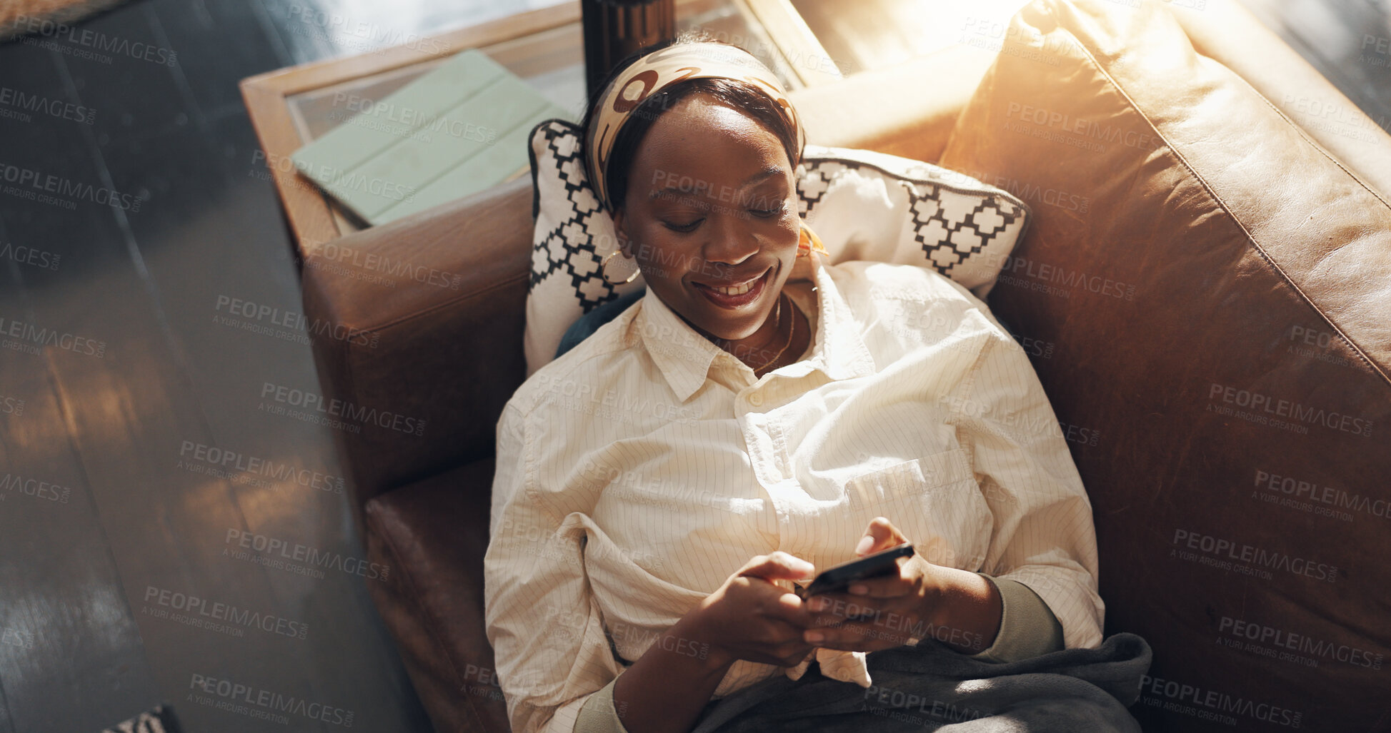 Buy stock photo Black woman, happy and relax with phone in home for social media browsing, online news and streaming. Above, comfortable and person with smartphone on sofa for app download and scrolling dating site
