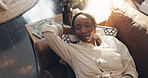 Above, relax and black woman on sofa, thinking and calm with weekend break, peace and daydreaming. Apartment, choice or African person on couch, decision and thoughtful with wonder, home or wellness
