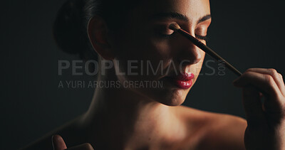 Buy stock photo Makeup, brush and woman in studio with eyeshadow, beauty or facial routine with products. Cosmetics, self care and female person with tool for face cosmetology treatment for glow by black background