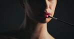 Cosmetics, brush and woman in studio with lipstick, beauty or facial routine with products. Makeup, self care and female person with tool for face cosmetology treatment for glow on black background