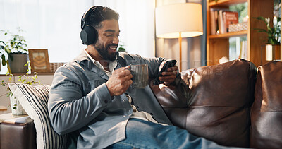 Buy stock photo Relax, man and phone with headphones on sofa for streaming music, audio subscription and video. Coffee, person and happy with smartphone in home for listening to album track, radio playlist and song