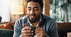 Coffee, smile and man on sofa in home with calm, peace or morning break with warm beverage. Happy, relax and male person drinking cappuccino, latte or tea for wellness in living room at apartment.